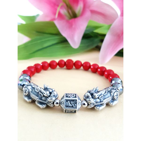 A pair of 23mm long-sleeved prayer beads and an Om Mani Padme Hum bracelet that are said to bring good luck and wealth.